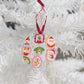 Decorative Christmas acrylic ornament with colorful designs on a white tree.